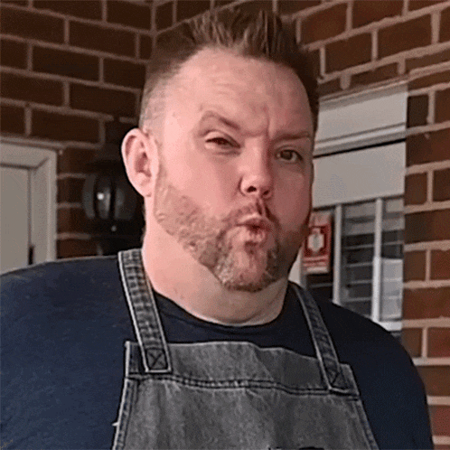 a man wearing an apron making a funny face