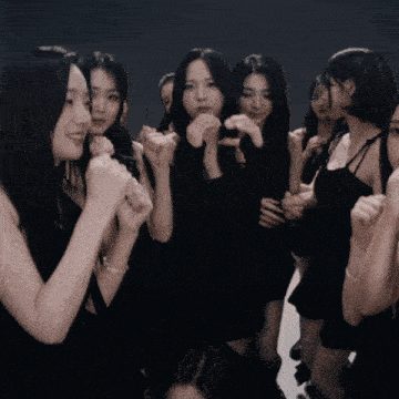 a group of women in black dresses are standing in a circle