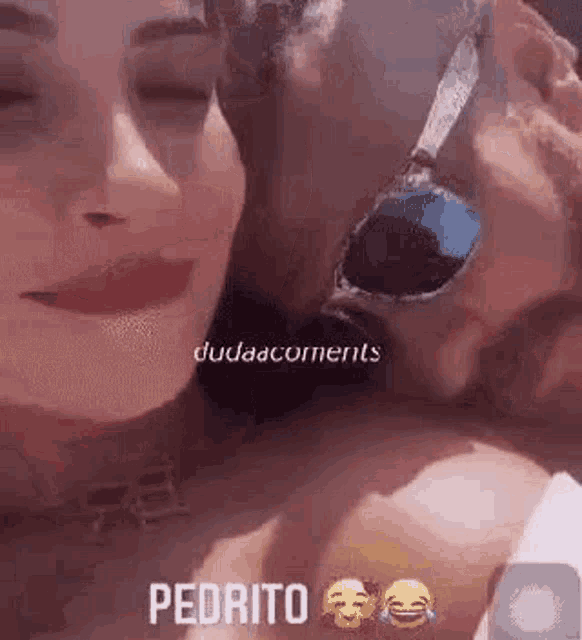 a man and a woman are kissing each other while wearing sunglasses .