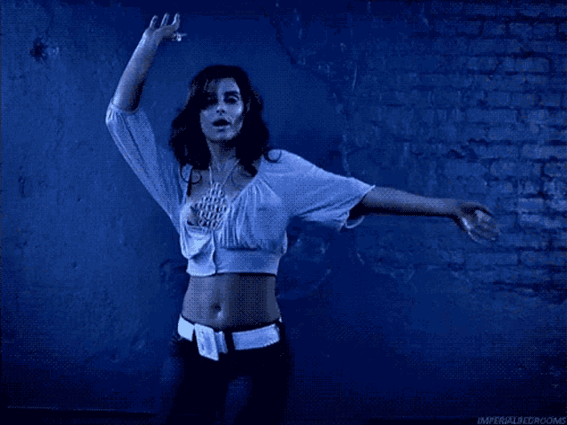 a woman with her arms outstretched in front of a blue wall that says imperial bed rooms