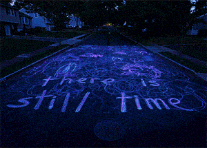 someone has written " there is still time " in chalk on the sidewalk