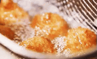 a close up of a frying pan filled with fried food and a spatula .