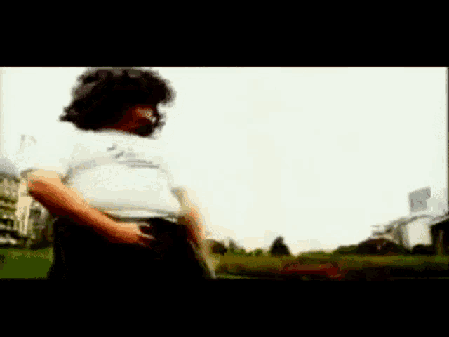 a blurred image of a person with a white shirt that says ' a ' on it