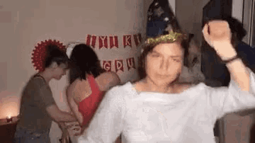 a woman wearing a party hat is dancing with a group of people .