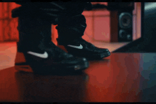 a person is wearing a pair of black nike boots