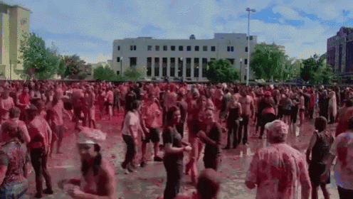 a large crowd of people are covered in red powder