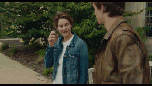 a man and a woman are standing next to each other on the sidewalk