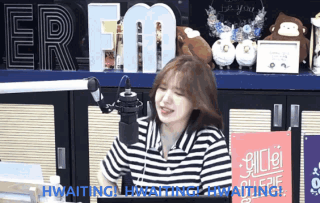 a woman in a striped shirt is sitting in front of a microphone in front of a sign that says " er fm "