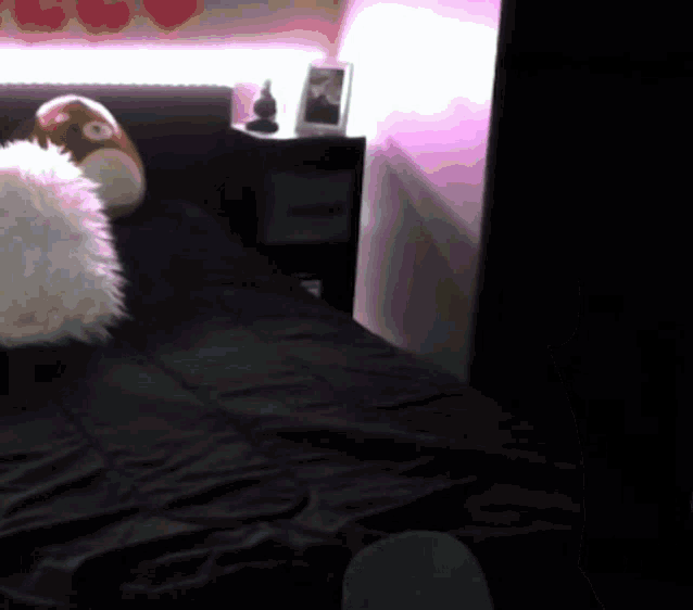 a bed with a penguin pillow on it