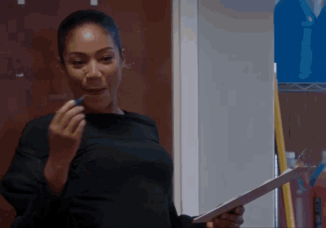 a woman is holding a clipboard and a pen