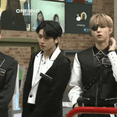 a group of young men are standing in front of a screen with korea written on it
