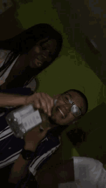 a man with glasses is drinking from a glass