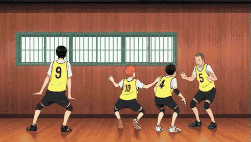 a group of volleyball players are standing next to each other in a gym .