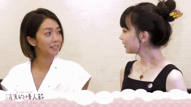 two women standing next to each other with chinese writing on a pink background