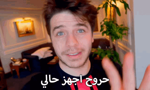 a man is wearing a black shirt with arabic writing on it