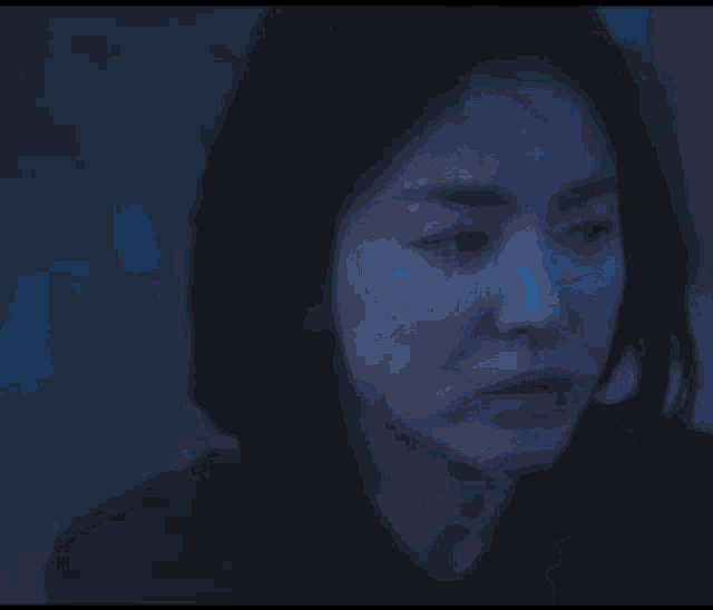 a woman is eating a piece of ice in the dark .