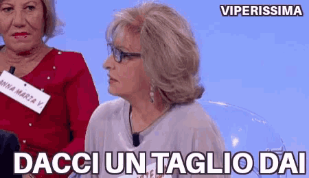 two women are sitting next to each other and one of them is wearing glasses and a name tag that says anna marta v.