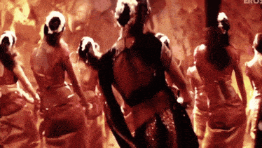 a woman in a black top is dancing in front of a crowd with eros written on the bottom