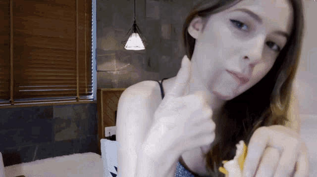 a woman is giving a thumbs up while eating a sandwich