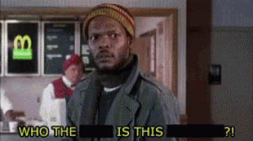 a man is standing in front of a sign that says who the is this ?