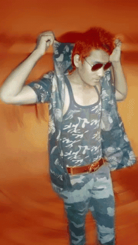 a man with red hair wearing sunglasses and a camouflage shirt