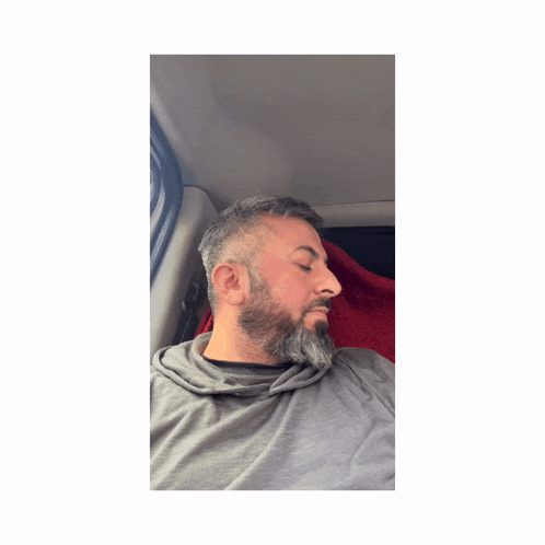 a man with a beard wearing a grey shirt