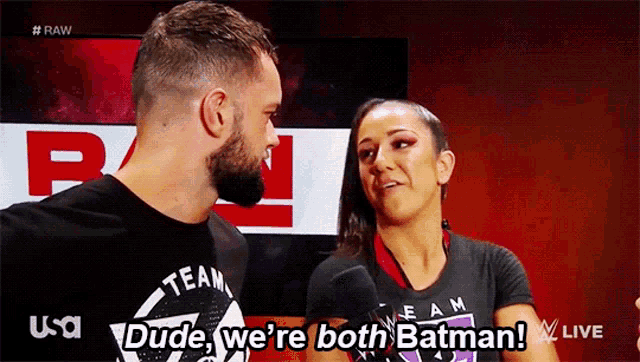 a man and a woman are talking and the woman is wearing a black shirt that says team