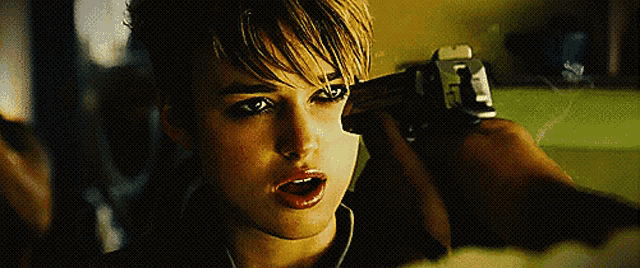 a close up of a person holding a gun with the letter l on the side