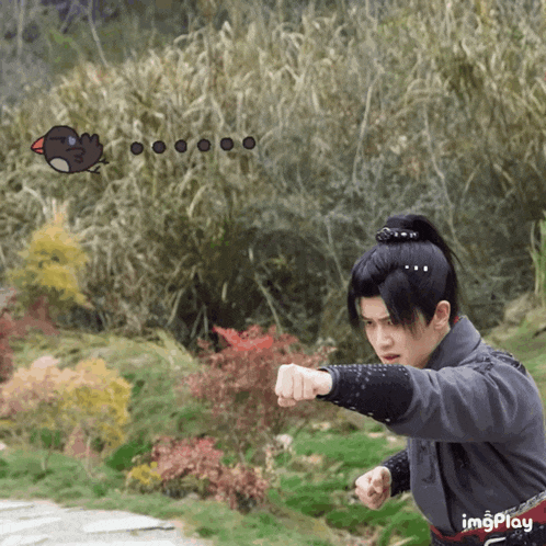 a man in a ponytail holds his fist up in front of a bird that says imgplay on the bottom
