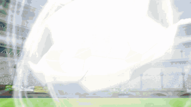 a white and black soccer ball is floating in the air on a soccer field