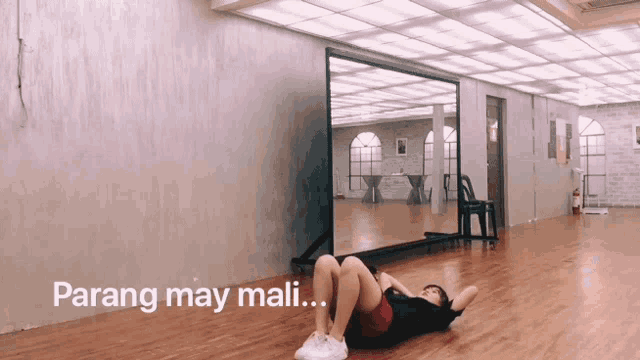 a woman laying on her stomach in front of a large mirror with the words parang may mali