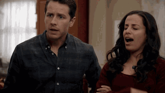 a man and a woman are standing next to each other and the woman is yawning