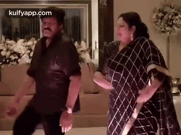 a man and a woman are dancing in a room .