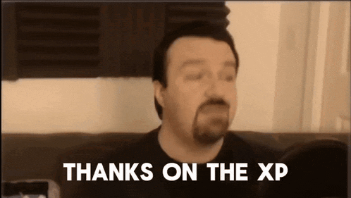 a man with a beard is sitting on a couch with the words thanks on the xp above him