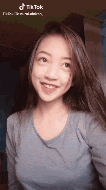 a girl with long hair is smiling for a tiktok