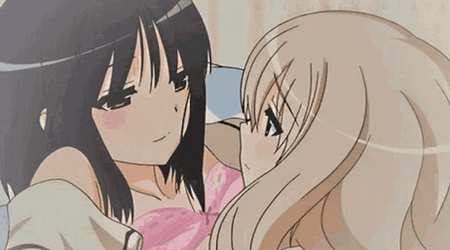 a couple of anime girls are kissing each other on the cheek .
