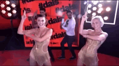 a group of people are dancing on a red carpet in front of a wall that says dale 's