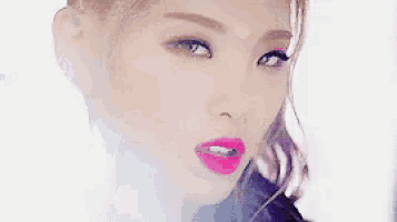 a close up of a woman 's face with bright pink lipstick .