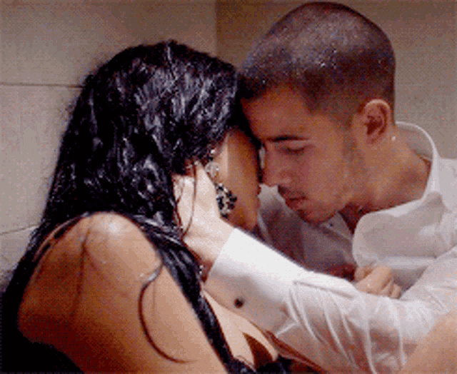 a man and woman are kissing in a bathroom