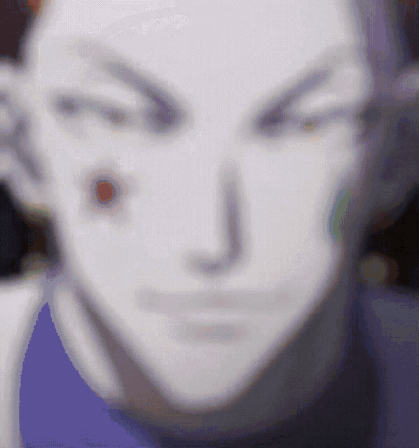 a blurry picture of a man 's face with a red spot on his forehead .