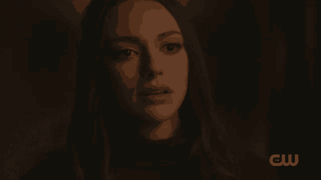 a close up of a woman 's face with the cw logo in the background