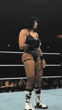a woman is standing in a wrestling ring with her butt visible