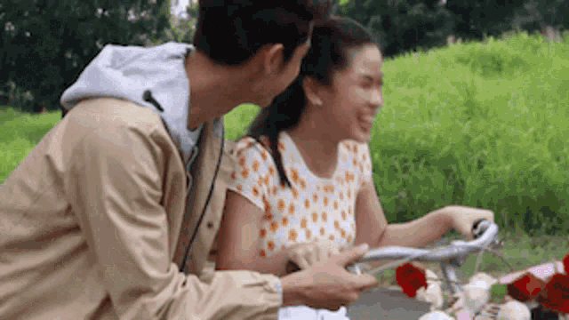 a man is kissing a woman on the cheek while riding a bike .