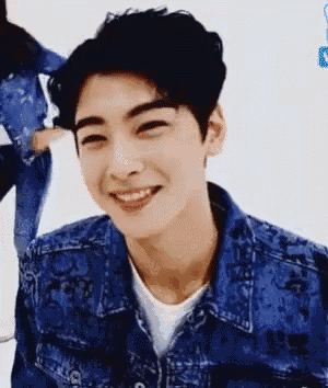 a young man in a denim jacket is smiling and looking at the camera .