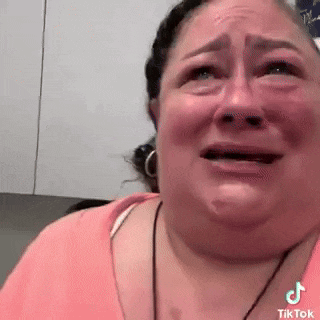 a woman is crying while looking at the camera .