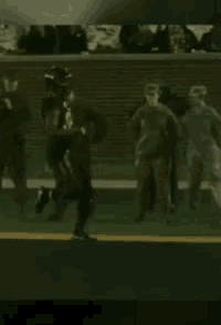 a football player is being tackled by another player on a field