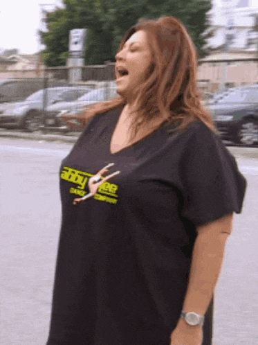 a woman wearing an abby free t-shirt is singing