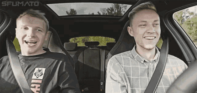 two men are laughing in a car with the word fumato on the bottom left