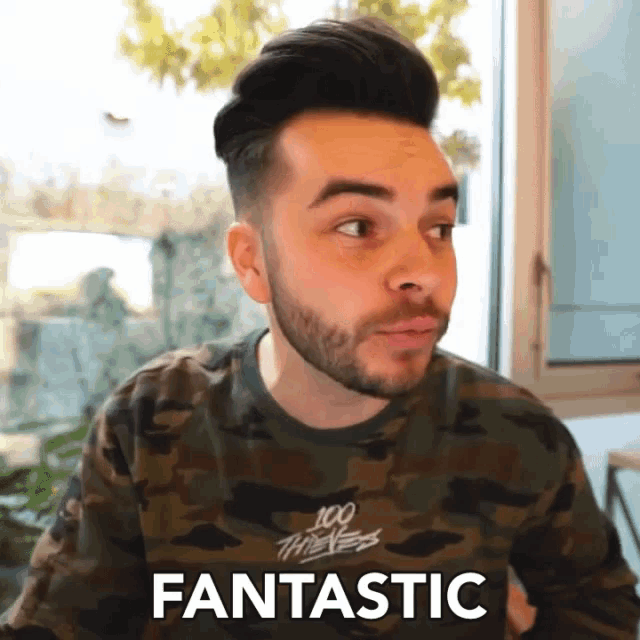 a man with a beard is wearing a camouflage shirt that says fantastic