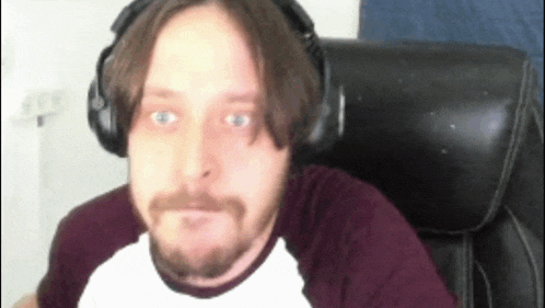 a man with a beard is wearing headphones and a white shirt